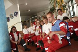 Die Übungsteilnehmer des Roten Kreuzes besprechen die Übung in der Aula nach